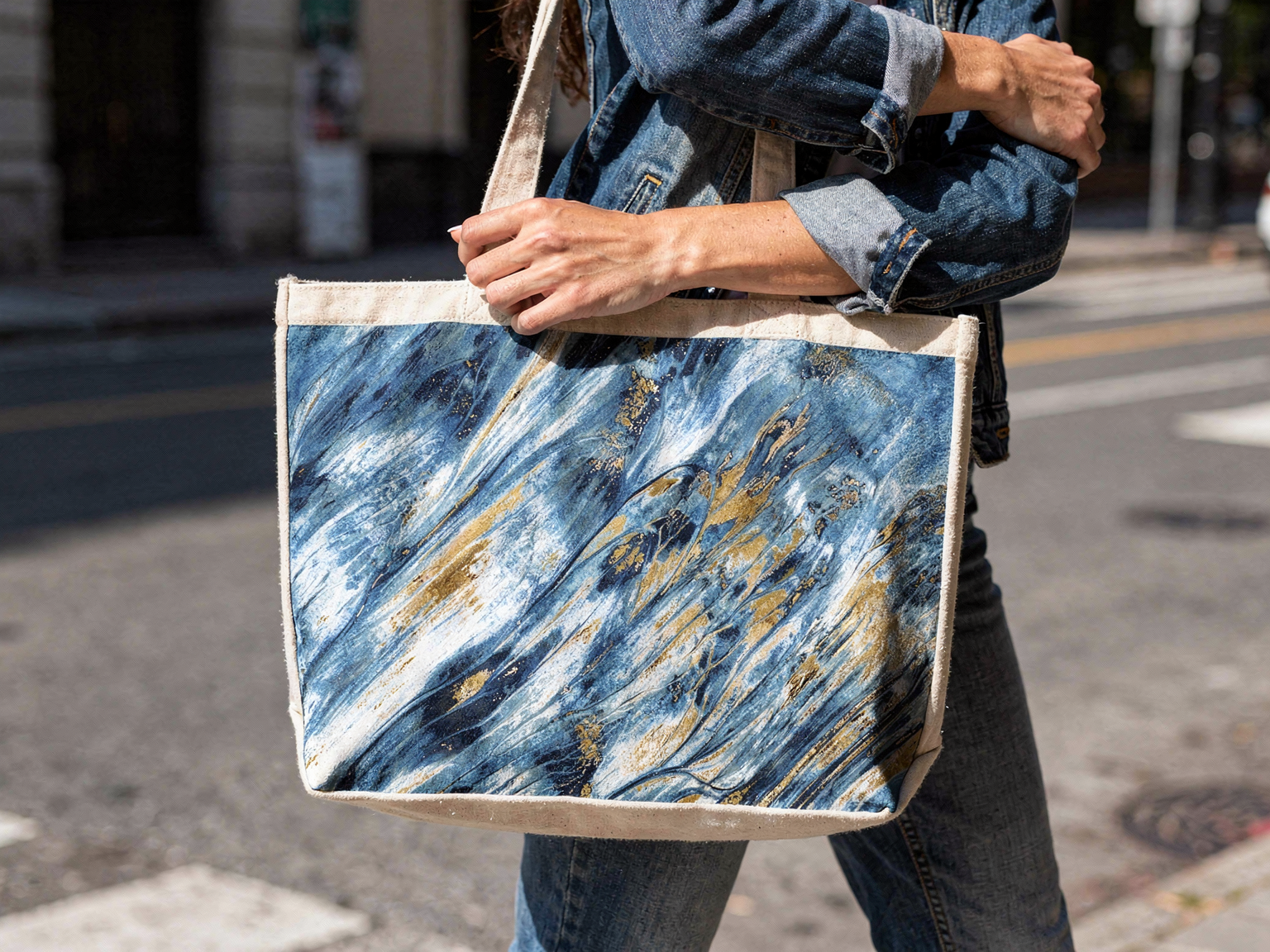 "Canvas tote bag featuring Golden Tides fluid art design - lifestyle mockup in urban street setting"